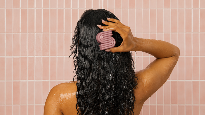 Woman using Castor Oil Nourishing Shampoo Bar by KITSCH to avoid hair static