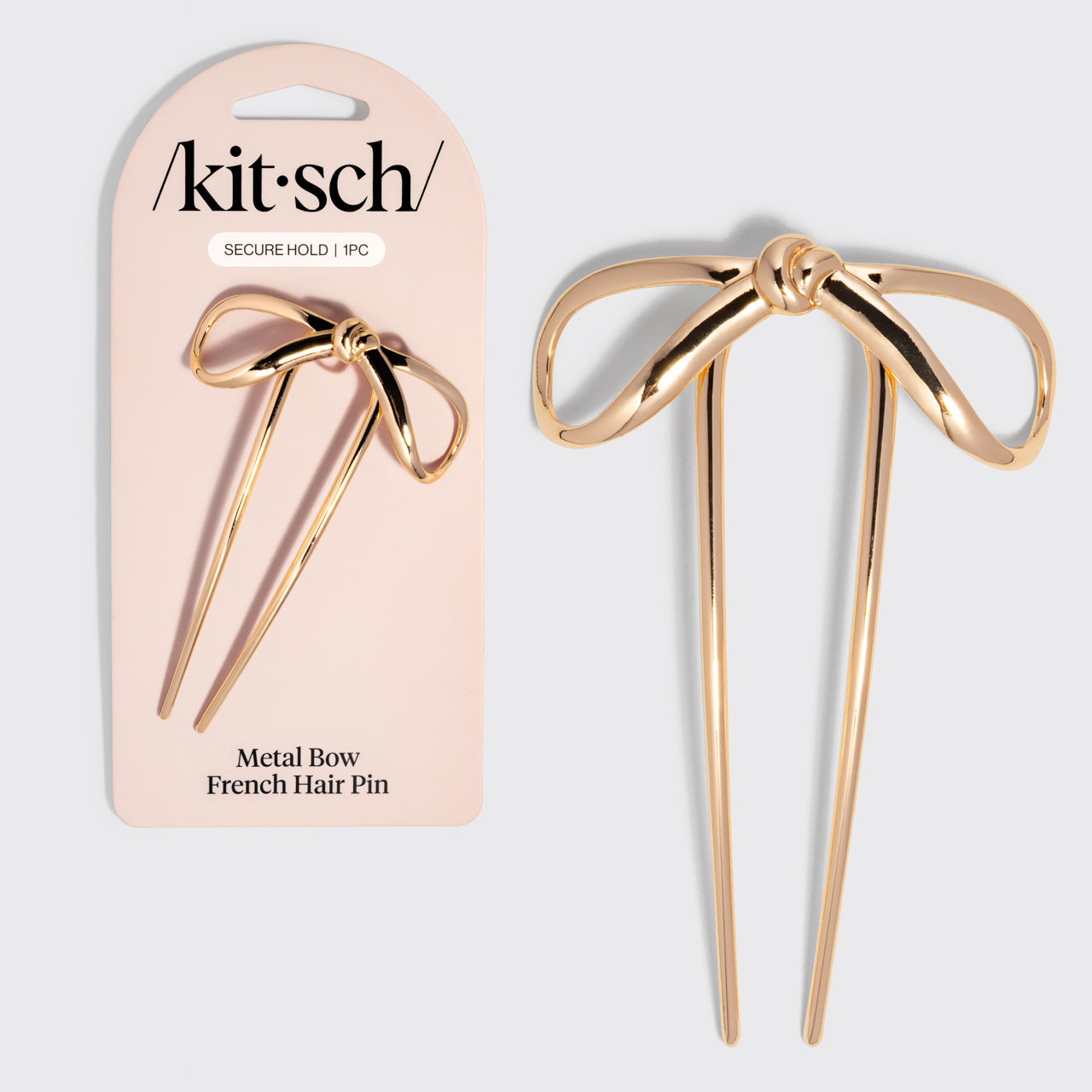 Gold metal bow French hair pin with packaging displaying 'kitsch' brand on a light gray background.