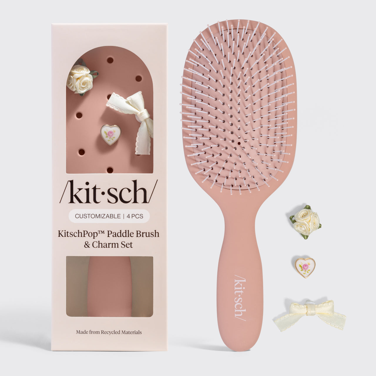 Kitsch paddle brush and charm set packaging on a gray background