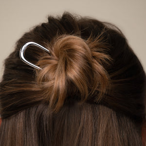 Close-up of a half-up hair bun with the kitsch silver mini metal french clip.