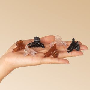KITSCH Recycled Plastic Mini Arched Clips 6pc Set — model hand holding all 6 clips, Soft Pink, Mocha & Black — Made from Recycled Materials — all-day hold