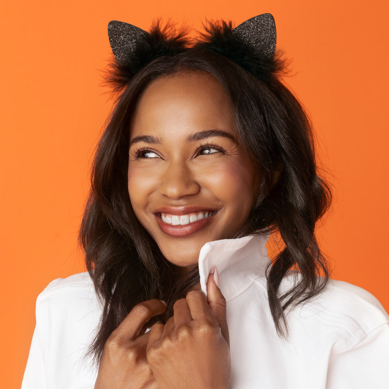 KITSCH Black Glitter Satin Cat Ears Headband — lifestyle model shot styling the cat ears headband — sparkly glitter ears and plush faux-fur trim